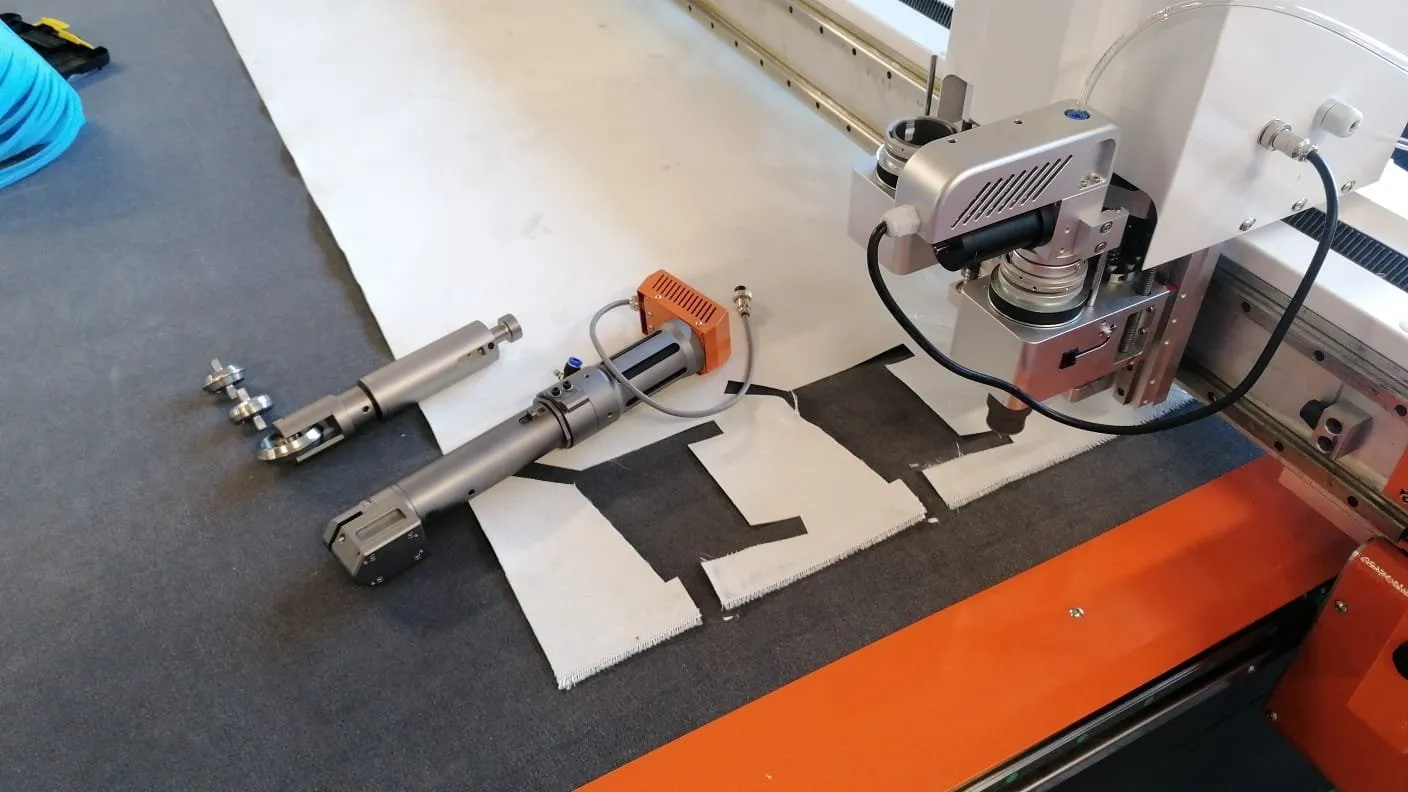 Detail moderního CNC stroje s automatizačními komponenty na pracovním stole.