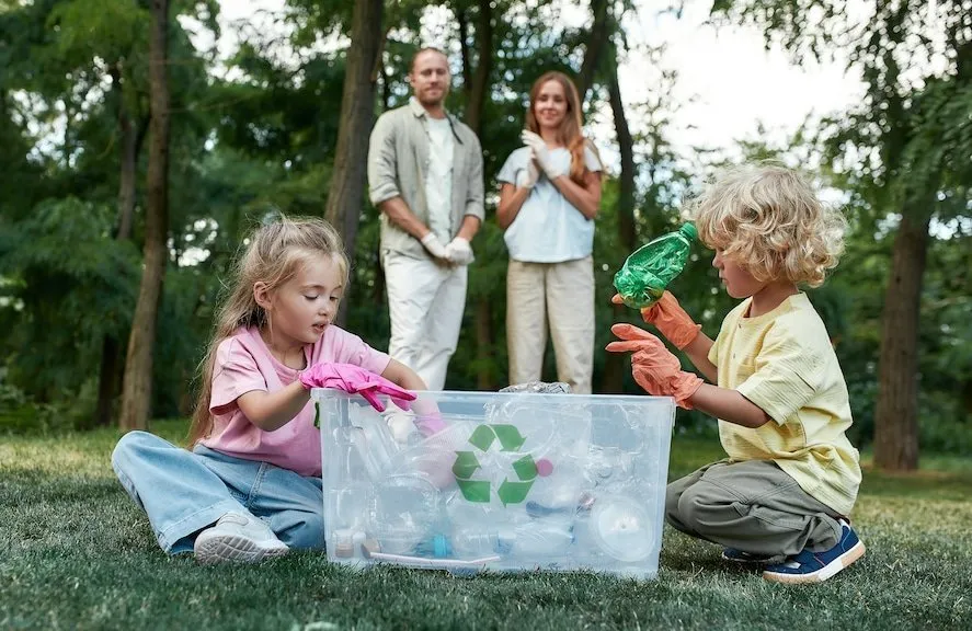 Děti třídí recyklovatelný odpad v přírodním prostředí.