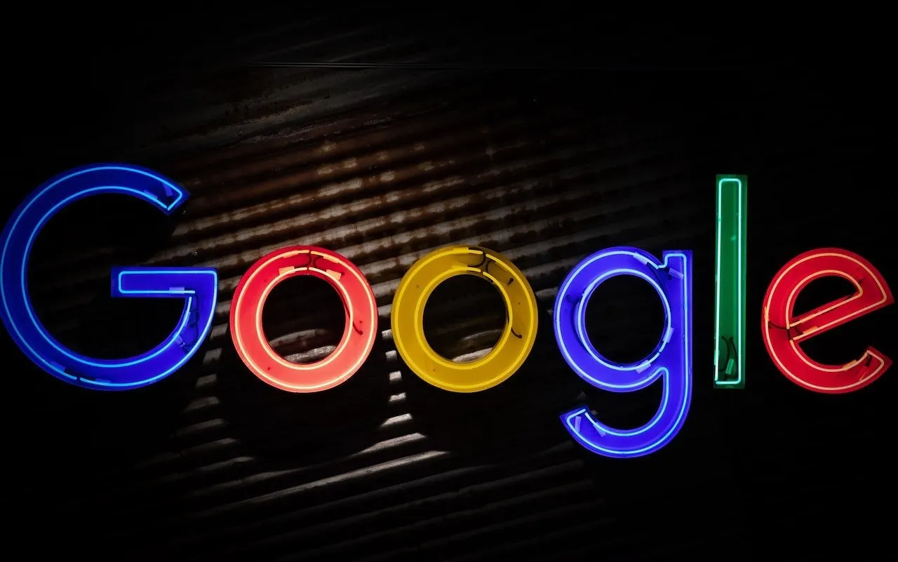 Barevný neonový nápis loga Google na tmavém pozadí.